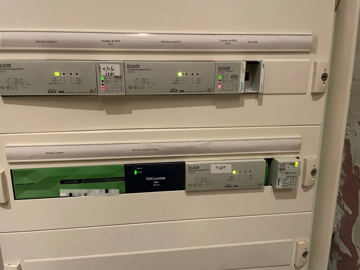 Miniserver Loxone installé dans un tableau à côté des alimentations de bus et des coupleurs KNX d'une installation existante