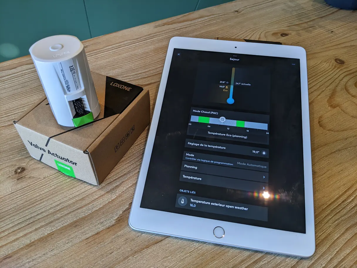Actionneur de vanne Loxone et interface de régulation du séjour affichée sur tablette : température de consigne, mode et planning
