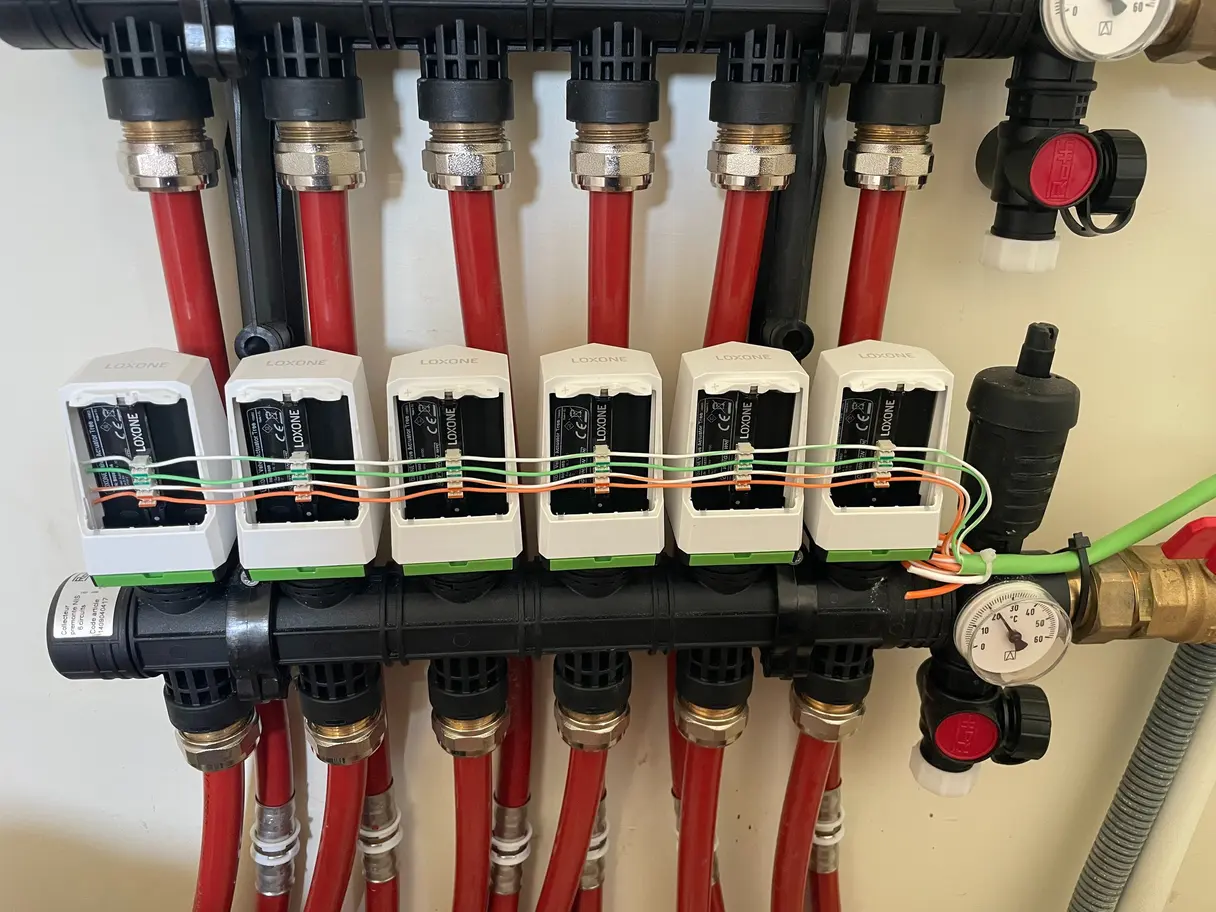 Détail des six têtes thermostatiques Loxone câblées sur le collecteur de plancher chauffant