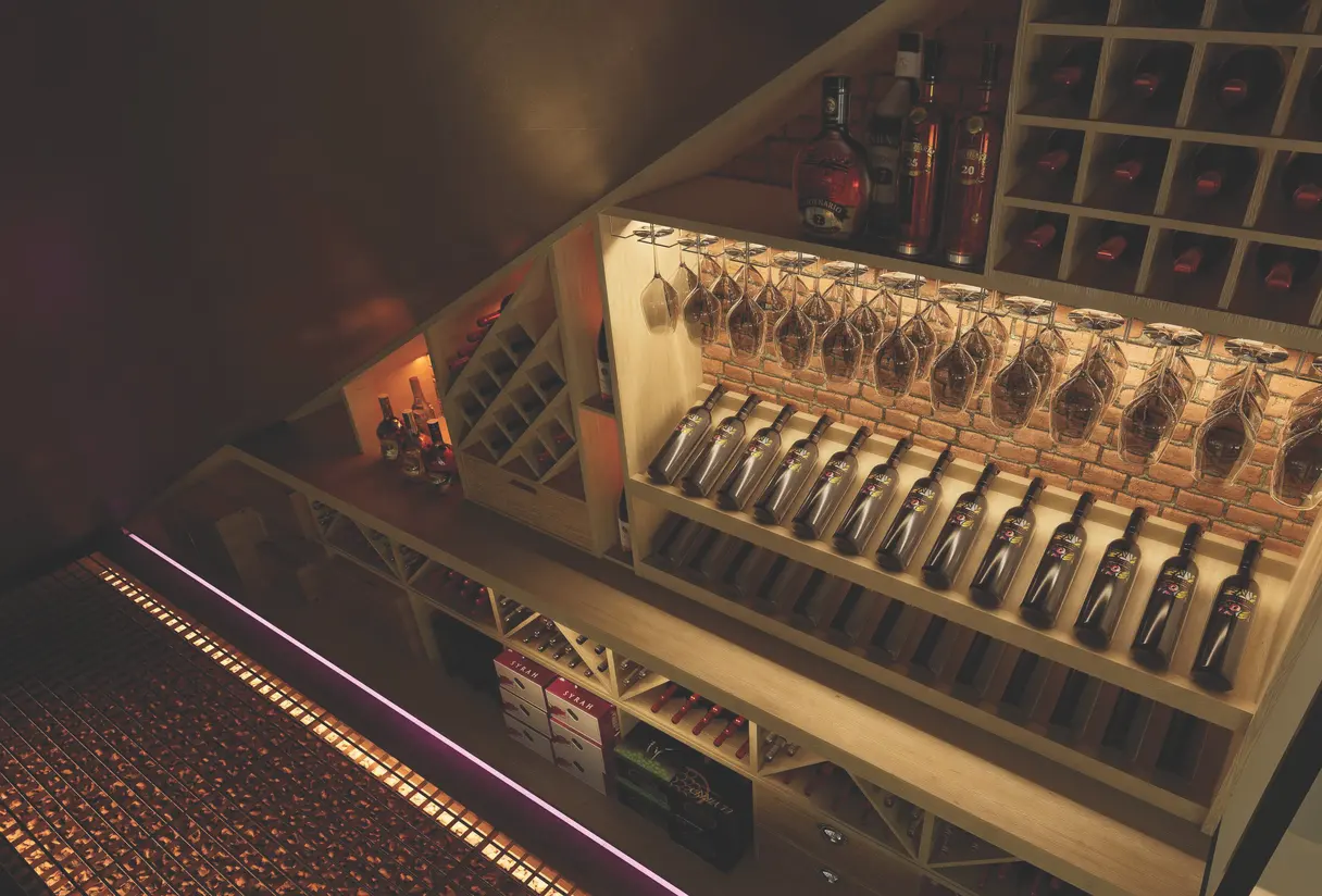 Rendu 3D de la cave vue de dessus : bouteilles alignées sous les verres suspendus et bandeau LED