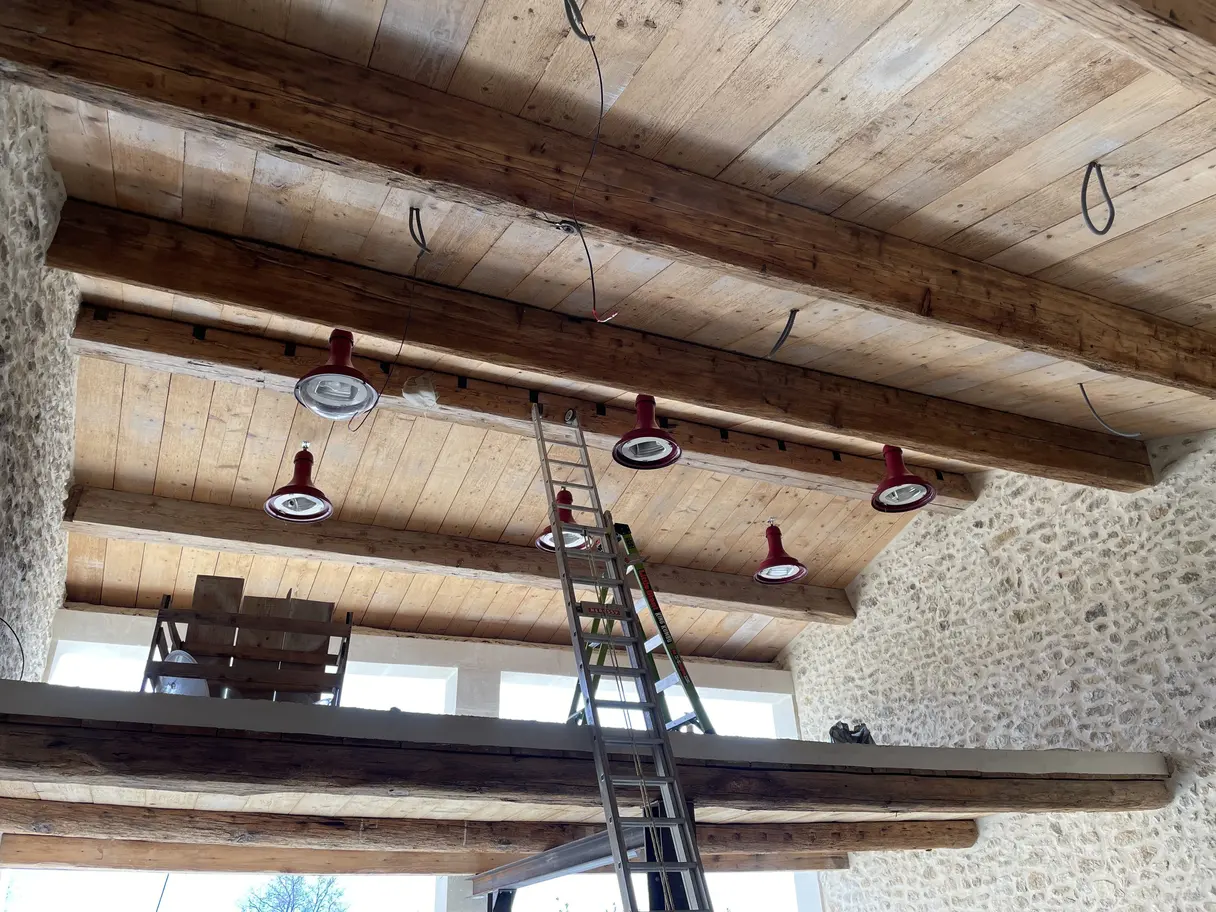 Rampe de spots encastrés dans le plafond bois du garage, en cours d'installation