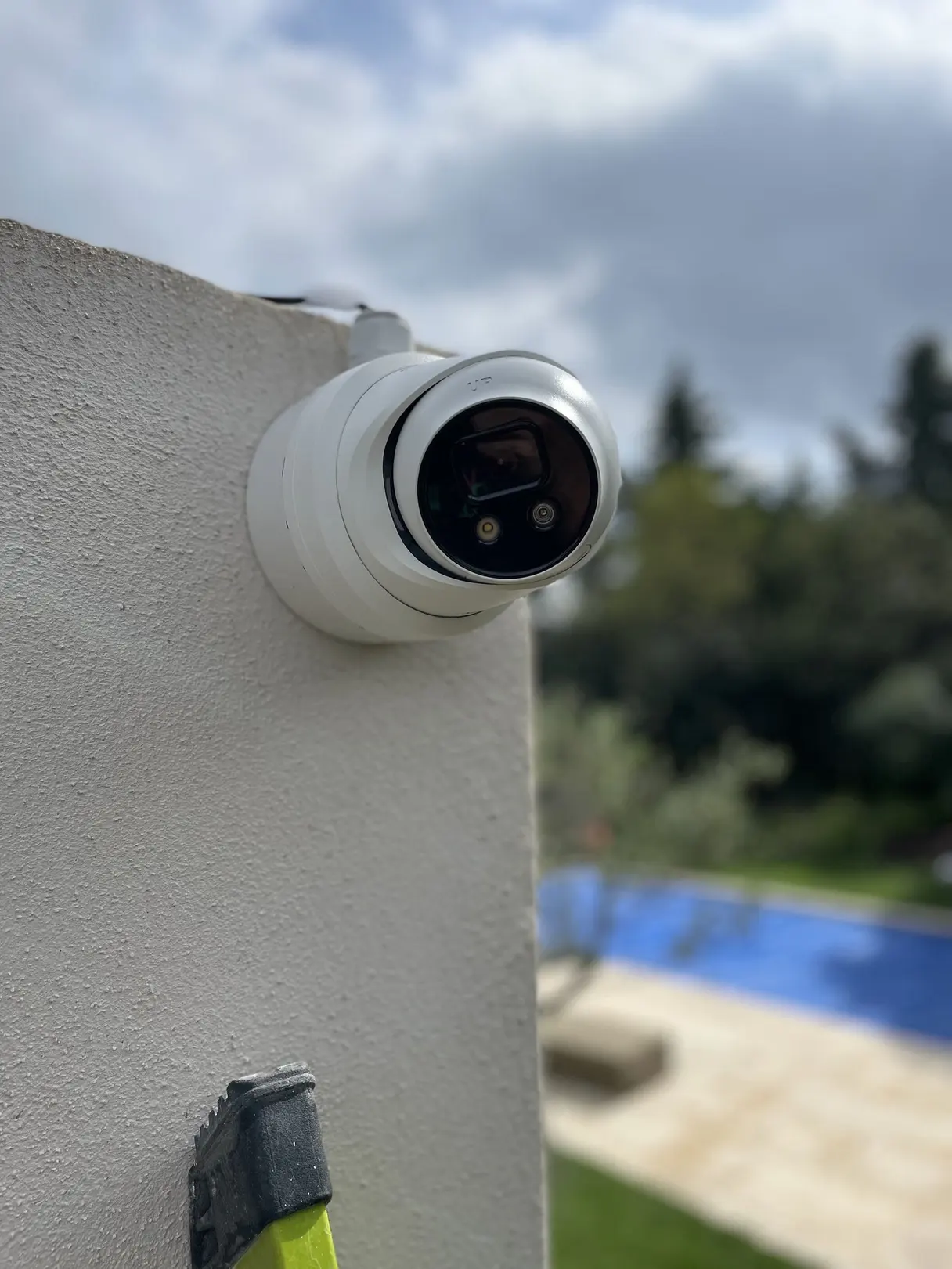 Caméra dôme installée en angle de façade, orientée vers la piscine