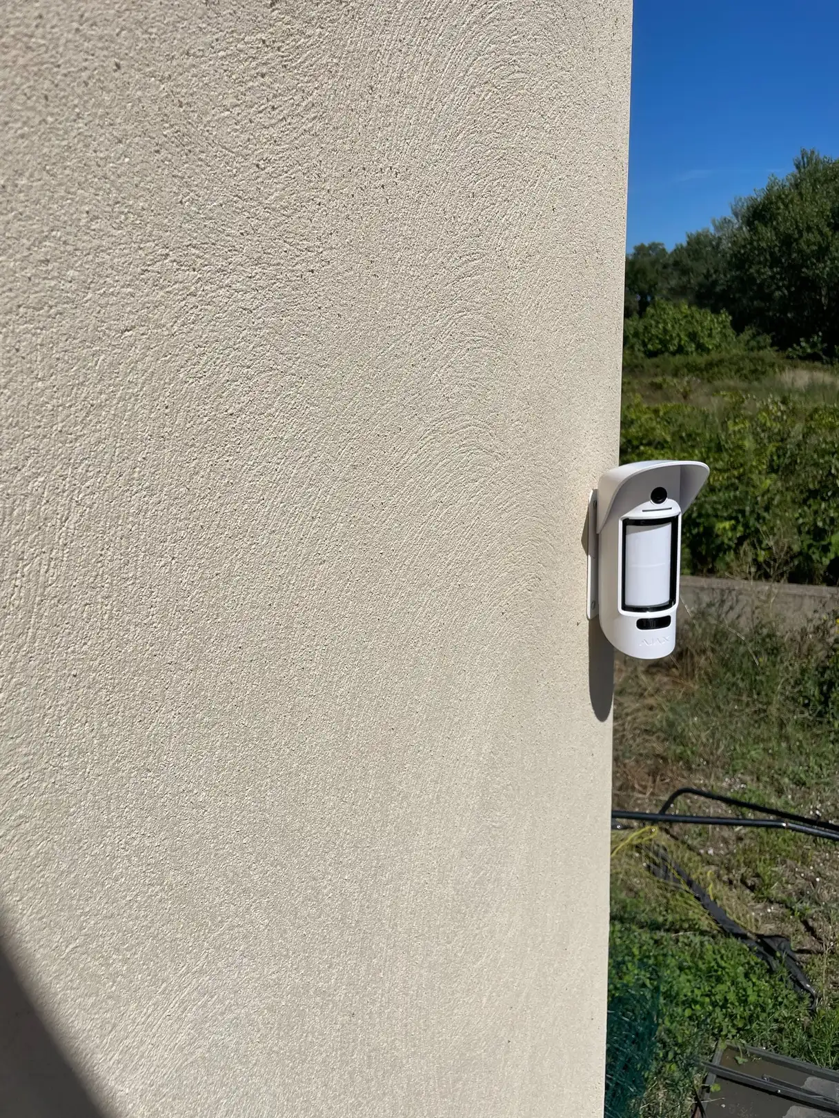 Détecteur de mouvement extérieur avec caméra intégrée, fixé en angle de façade