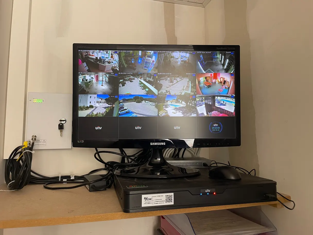 Poste de supervision : enregistreur vidéo et écran affichant les huit caméras du site